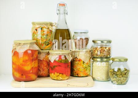 Fermentierte konservierte vegetarische Nahrung Konzept. Vielfalt an vegetarischen Produkten und fermentierten Lebensmitteln in Gläsern zur Lagerung auf weißem Holztisch. Probi Stockfoto