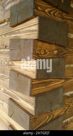 Fischgrätfuge, traditionelle Tischlerfugen, braunes Holz an der Ecke des Holzhauses Stockfoto