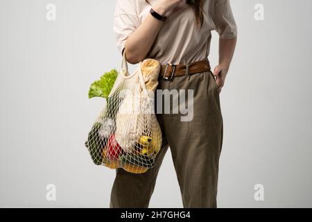 Frau mit wiederverwendbarem Öko-Baumwollbeutel und frischem Bio-Gemüse. Lokale Bauern gesunde Lebensmittel. Keine Verschwendung. Speicherplatz kopieren. Stockfoto