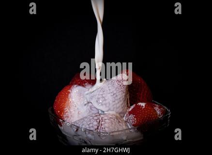 In einer Glasschüssel frische Erdbeeren und Milch aus einem hohen Winkel. Stockfoto