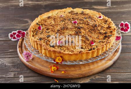 Birnenkuchen und Schokolade bröckeln mit essbaren Blüten. Französische Gourmetküche Stockfoto