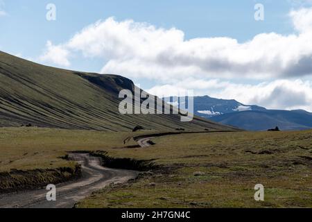 Panoramablick über das Hochplateau mit Schotterstraße in der Nähe des Vulkans Katla in Island mit Bergen im Hintergrund ein weiß getrübter blauer Himmel Stockfoto