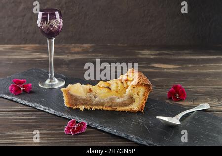 Pear Peach Pie mit Haselnusscreme, Haselnüssen und essbaren Blumen in Scheiben schneiden. Französische Gourmetküche Stockfoto