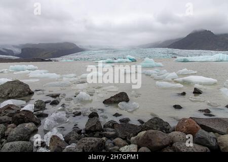 Nahaufnahme eines Gletschereises und Felsens in der Lagune vor dem Endpunkt oder Ende des Jokulsarlon Gletschers, Island im Hintergrund Stockfoto