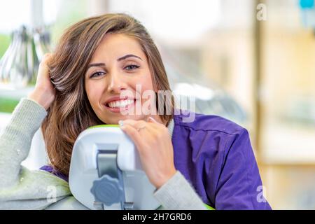 Junge lächelnde Frau am Zahnarztstuhl Stockfoto