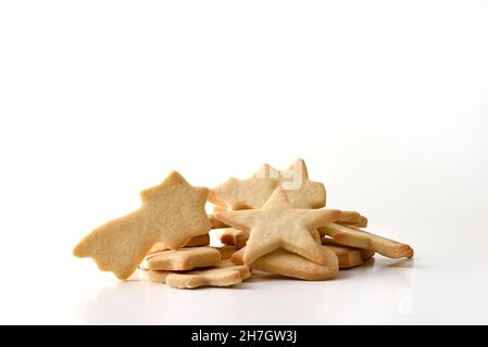 Auswahl an weihnachtlich geformten Keksen in einem Stapel auf weißem, isoliertem Hintergrund. Vorderansicht. Horizontale Zusammensetzung. Stockfoto