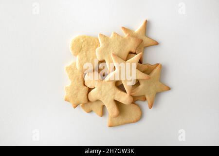 Auswahl an weihnachtlich geformten Plätzchen in einem Stapel auf weißem Tisch. Draufsicht. Horizontale Zusammensetzung. Stockfoto