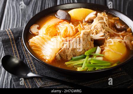 Der koreanische Gamjatang ist ein würziger, herzhafter Eintopf, der mit Schweineknochen aus nächster Nähe in der Schüssel auf dem Tisch zubereitet wird. Horizontal Stockfoto