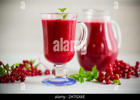 Frisch gepresster dicker natürlicher Saft mit Fruchtfleisch aus reifen roten Viburnum in einer Karaffe Stockfoto