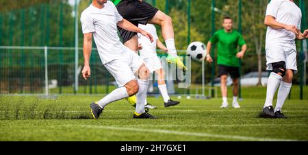 Gruppe von erwachsenen Fußballspielern in einem Duell. Fußballspieler treten Spiel auf Grass Field. Fußball vorwärts und defensive Spieler im Wettbewerb Stockfoto