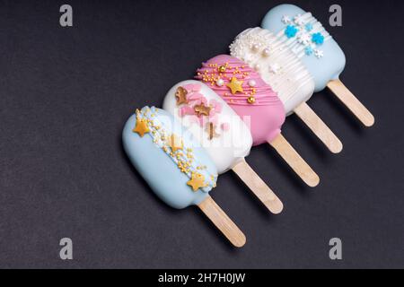 Dekorierte Kuchen knallt Eis auf schwarzem Hintergrund Stockfoto