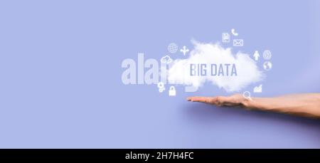 Geschäftsmann hält die Inschrift , Wort BIG DATA . Vorhängeschloss, Gehirn, Mann, Planet, Graph, Lupe, Zahnräder, Symbol für Cloud, Grid, Dokument, Brief, Telefon Stockfoto