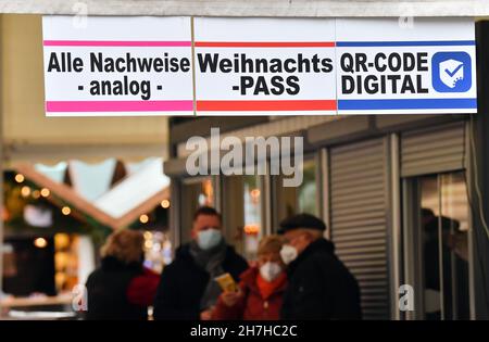 Erfurt, Deutschland. 23rd. November 2021. Besucher werden an einem Eingang zum Erfurter Weihnachtsmarkt kontrolliert. Die meisten thüringischen Städte haben ihre Weihnachtsmärkte aufgrund der besorgniserregenden Infektionszahlen gestrichen. Nun steht eine Verschärfung der Corona-Maßnahmen in den Angen. Am 24. November wird der landtag über weitere Einschränkungen diskutieren. Daher ist derzeit unklar, ob die Weihnachtsmärkte bis Ende Dezember geöffnet bleiben dürfen. Quelle: Martin Schutt/dpa-Zentralbild/dpa/Alamy Live News Stockfoto