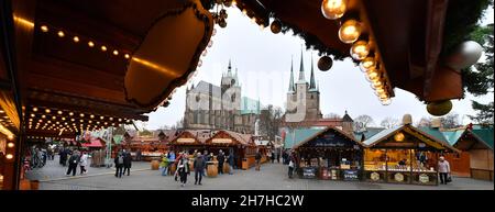 Erfurt, Deutschland. 23rd. November 2021. Besucher spazieren durch den Erfurter Weihnachtsmarkt. Die meisten thüringischen Städte haben ihre Weihnachtsmärkte aufgrund der besorgniserregenden Infektionszahlen gestrichen. Nun steht eine Verschärfung der Corona-Maßnahmen in den Angen. Am 24. November wird der landtag über weitere Einschränkungen diskutieren. Daher ist derzeit unklar, ob die Weihnachtsmärkte bis Ende Dezember geöffnet bleiben dürfen. Quelle: Martin Schutt/dpa-Zentralbild/dpa/Alamy Live News Stockfoto