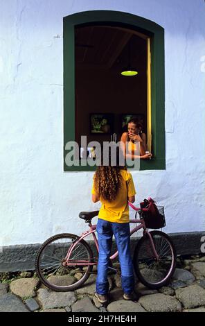 BRASILIEN, BUNDESSTAAT RIO DE JANEIRO, PARATY WURDE 1667 GEGRÜNDET, ARCHITEKTUR IM KOLONIALSTIL, GESPRÄCH VOR EINEM FENSTER ZWISCHEN ZWEI FRAUEN Stockfoto