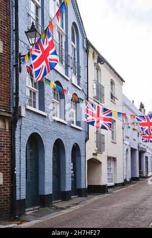 Ein Straßenblick auf die Gebäude der Courthouse Street, die mit einer bunten Dekoration für das Jack in the Green Festival in der Altstadt von Hastings, East Sussex, Großbritannien, dekoriert wurden. Stockfoto