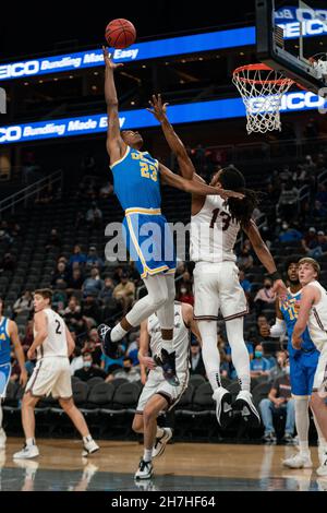 UCLA Bruins-Wächter Peyton Watson (23) steigt während eines NCAA-Basketballspiels am Montag, den 22. November, wegen einer Erholung gegen die Bellarmin Knights-Wache Dylan Penn (13) auf. Stockfoto