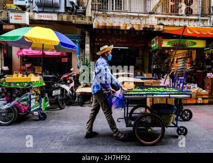 Ein Obsthändler schob seinen Wagen in Chinatown, Bangkok, Thailand, entlang der Straße Stockfoto