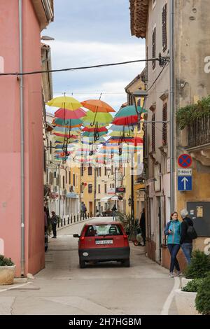 Offene Sonnenschirme, die an den Fäden in der Straße von Novigrad, Istrien, Kroatien, Europa hängen. Stockfoto