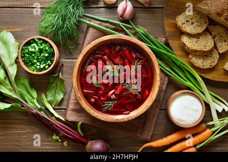 Traditionelle ukrainische russische Suppe (Borscht). Rote-Bete-Suppe in einer Schüssel auf Holzboden. Draufsicht, flach liegend Stockfoto