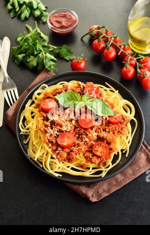 Leckere Spaghetti mit Hackfleisch, Kirschtomaten und Parmesankäse auf dem Teller, Nahaufnahme Stockfoto