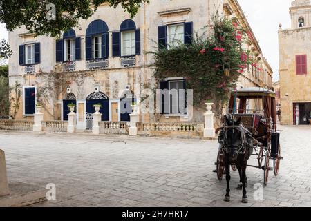 Traditionelle Architektur und Pferd und Wagen auf dem Bastion-Platz in der stillen Stadt Mdina, Malta. Eine alte ummauerte Stadt auf der UNESCO-Liste des Weltkulturerbes Stockfoto