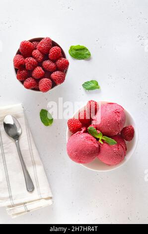 Himbeer-Eislöffel in einer weißen Schüssel. Draufsicht, flach liegend Stockfoto