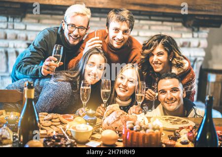 Glückliche Freunde auf Gruppenfoto Selfie Weihnachten mit Champagner und Süßigkeiten Essen bei Dinner Reunion Party feiern - Winterurlaub Konzept Stockfoto