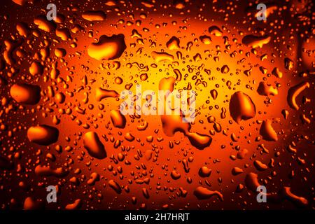 Hintergrund. Nahaufnahme. Tropfen auf ein Glas mit einem Orangengetränk. Bier, Tee Stockfoto
