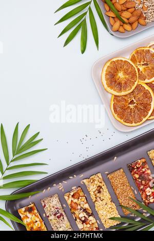 Lebensmittelzusammensetzung mit Müsliriegel mit Nüssen, Samen, Hafer, Beeren und trockenen Früchten auf blauem Hintergrund mit Kopierfläche. Natürliche Energie gesund Stockfoto