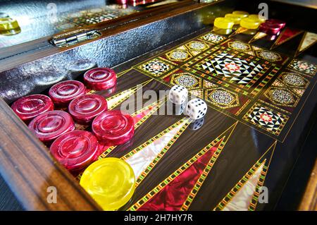 Bunte türkische Backgammon-Brett während des Spiels mit gelben und roten Steinen, Doppel sechs auf dem Brett Stockfoto