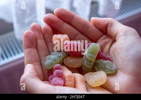 Frau hält Süßigkeiten, Nahaufnahme Foto von Gelee Süßigkeiten in der Hand des Mädchens. Stockfoto