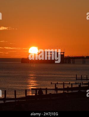 Worthing UK 23rd November - nach einem sonnigen, aber kalten Tag an der Südküste geht die Sonne hinter dem Worthing Pier unter : Credit Simon Dack / Alamy Live News Stockfoto