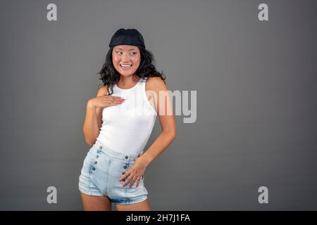 20/24 Jahre altes chinesisches Mädchen mit Bandana auf neutralem Hintergrund, witziger Ausdruck. Stockfoto