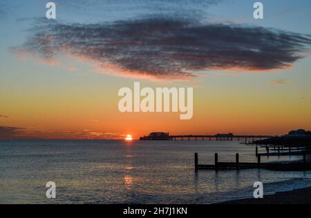 Worthing UK 23rd November - nach einem sonnigen, aber kalten Tag an der Südküste geht die Sonne hinter dem Worthing Pier unter : Credit Simon Dack / Alamy Live News Stockfoto