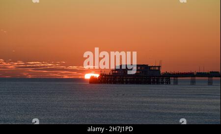 Worthing UK 23rd November - nach einem sonnigen, aber kalten Tag an der Südküste geht die Sonne hinter dem Worthing Pier unter : Credit Simon Dack / Alamy Live News Stockfoto