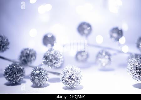 Unschärfem Weihnachtshintergrund. Weißer, silberner, graublauer Weihnachtshintergrund mit defokussierten Lichtern und geometrischen weihnachtlichen unscharfen Kugeln. Weiß oder si Stockfoto