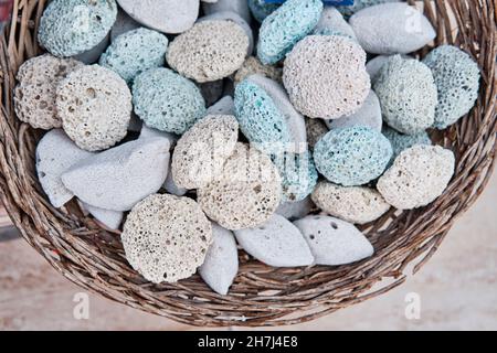 Farbige Bimssteine für Füße im Korb als Andenken für Touristen. Vulkanisches Gestein mit poröser Struktur. Stockfoto