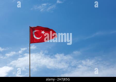 Türkische Flagge schwenkten im blauen Himmel. Stockfoto