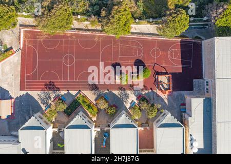 Luftaufnahme eines Sportgeländes für Mannschaftsspiele des Sports, des Basketballs, des Fußballs, des Volleyballs, des Handballs in einem Wohngebiet, im Hof von educati Stockfoto