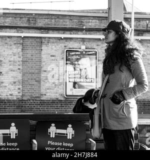Clapham Junction London England Großbritannien, November 7 2021, Junge ethnische Frau, die allein auf einen Zug auf der Clapham Junction Station Platform wartet Stockfoto