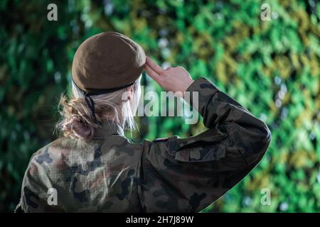 Eine Soldatin grüßt auf einem temporären Kommandoposten. Eine Frau in der polnischen Armee. Stockfoto