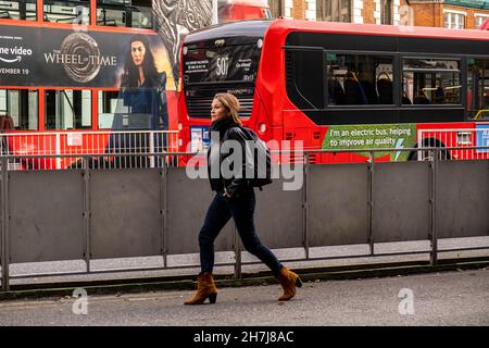 Victoria London England Großbritannien, November 21 2021, Frau allein, die an geparkten Londoner Red Double Deck Bussen im Busbahnhof Victoria vorbeigeht Stockfoto