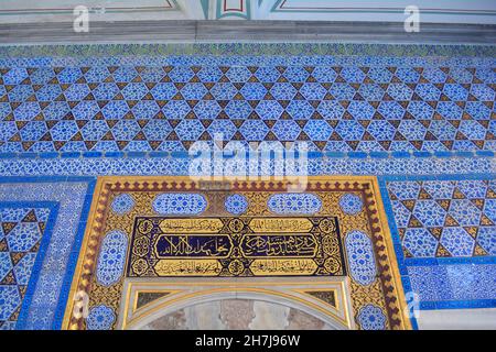 Istanbul, Türkei - 2021. November: Kunstvolle Keramikfliesen und arabische Inschrift an einer Wand im Topkapi-Palast. Stockfoto