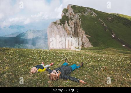 Familie Mutter und Kind entspannen in den Bergen liegen auf Gras zusammen reisen Abenteuer Urlaub Wandern im Freien gesunde Lebensweise Stockfoto