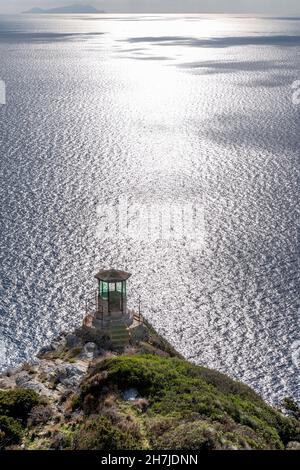 Wachturm auf der Insel Gorgona, mit der Insel Capraia im Hintergrund, Livorno, Italien Stockfoto