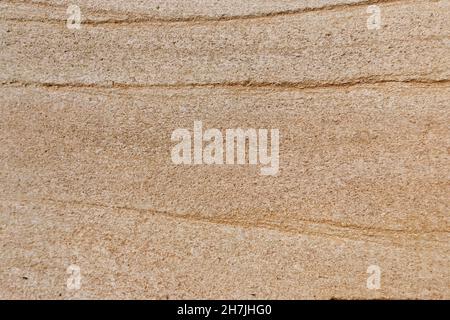 Natürliche Sandsteinstruktur. Nahaufnahme der geschichteten rauen körnigen Steinoberfläche. Flach liegend, Draufsicht. Verschiedene Brauntöne und Kopierraum. Stockfoto