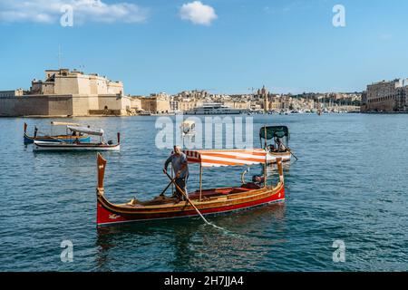 Valletta, Malta - Oktober 18,2021. Alte hölzerne lokale Fährschiffe von Valletta nach Birgu Vittoriosa. Traditionelles maltesisches Wassertaxi mit Schiffen Stockfoto