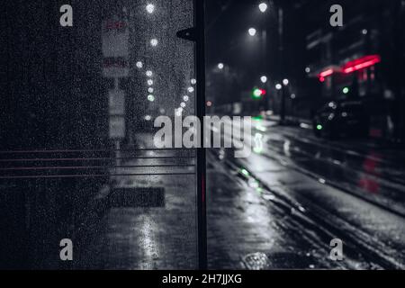 Schwarz-weiße Landschaft. Blick auf die Straße. Leere Straße in einer regnerischen Nacht. Das Wetter war launisch. Neonschilder, einsames Gefühl. Hochwertige Fotos Stockfoto