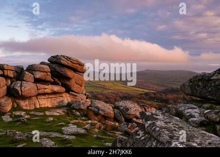 Dartmoor, Devon, Großbritannien. 23. November 2021. Wetter in Großbritannien: Ein spektakulärer Sonnenuntergang über Dartmoor, während sich grüblernde Wolken über Pew Tor sammeln, während das Wetter nach einem hellen und sonnigen Tag bricht. Kredit: PQ/Alamy Live News Stockfoto